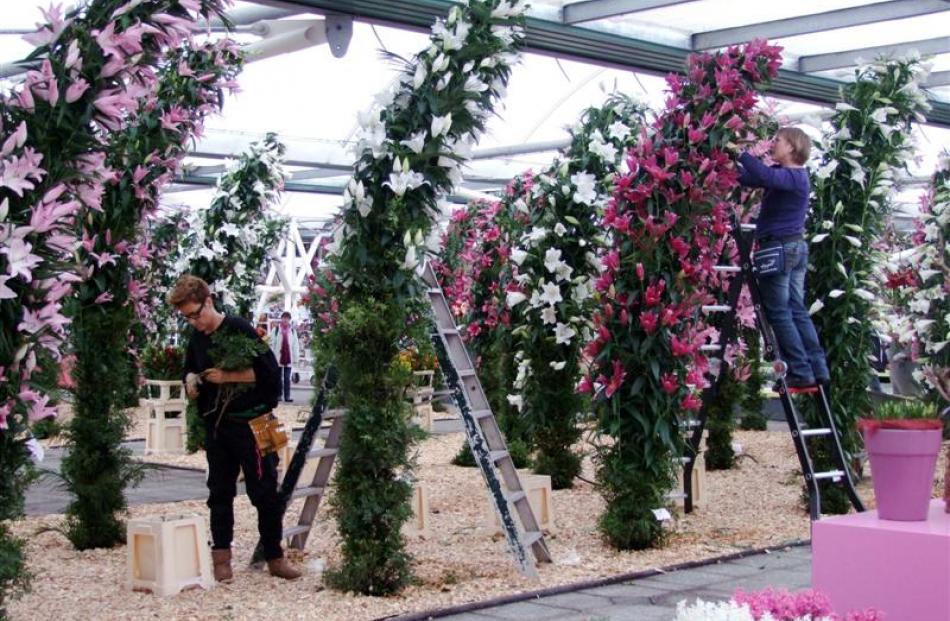 Staff refresh the lilies displayed on pillars in the Willem-Alexander pavilion.