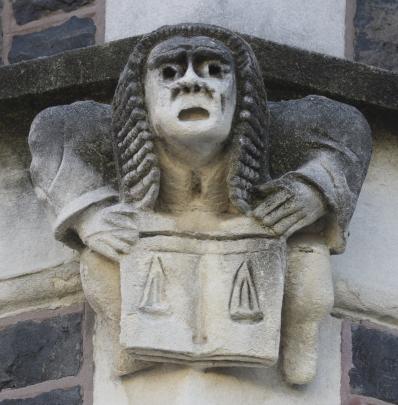 A figure wearing a judicial wig holds the scales of justice.
