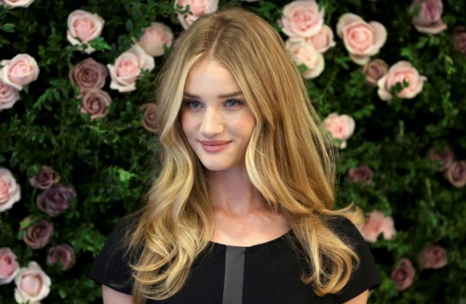 Actress Rosie Huntington-Whiteley poses for photographers during the launch of her 'Rosie for...