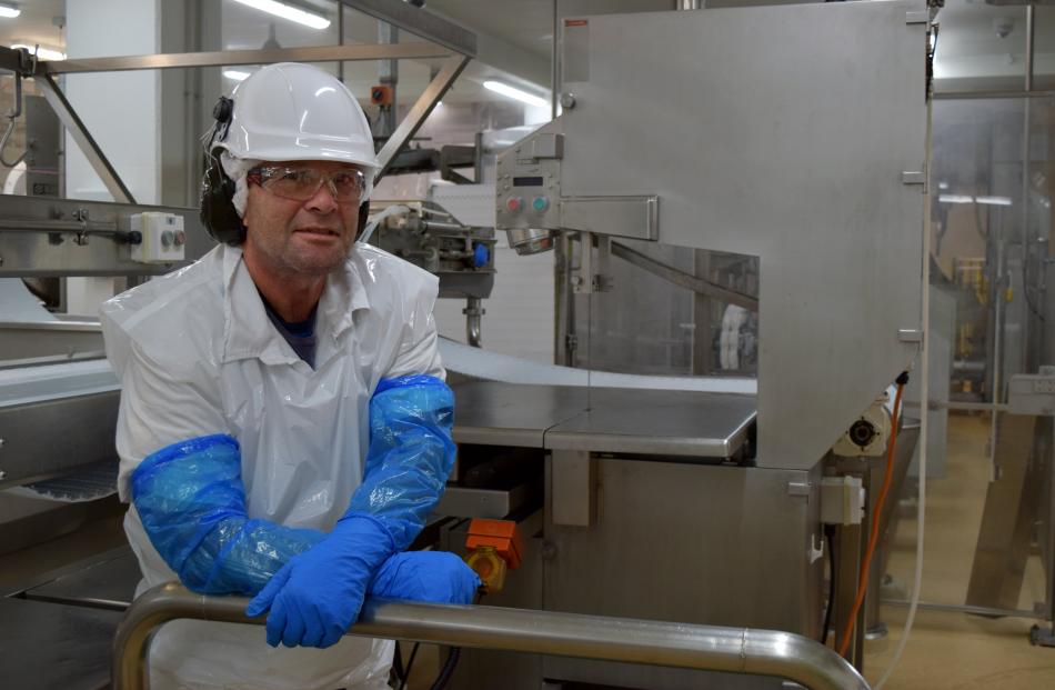 Alliance Group sawman Andrew McLaren relaxes by a BladeStop bandsaw in the Pukeuri plant last week.