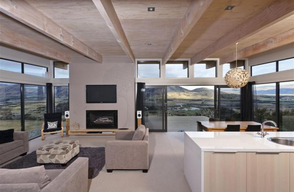 Large expanses of glass capture views of the Clutha River basin and decks hover in the landscape....