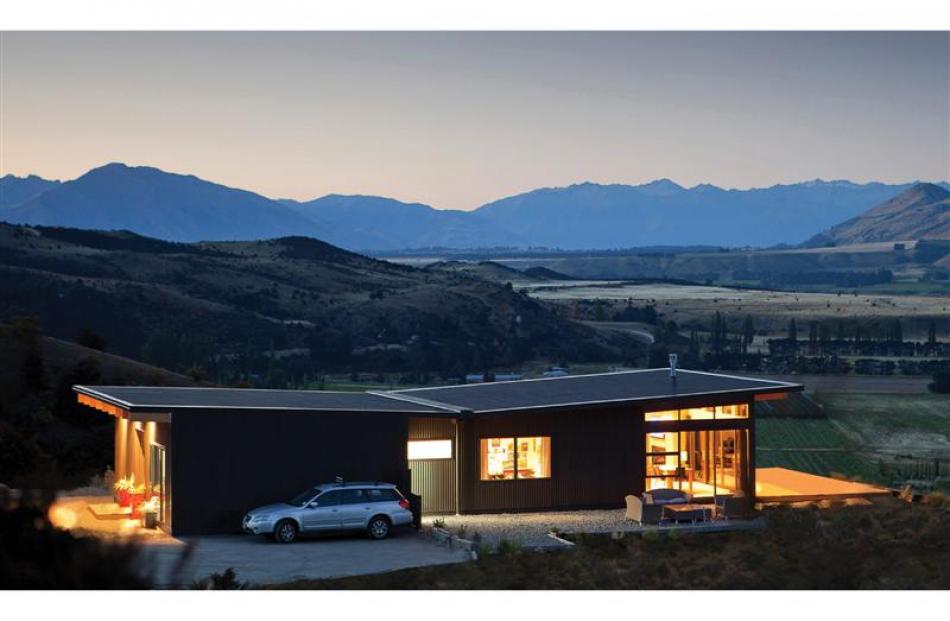 Large expanses of glass capture views of the Clutha River basin and decks hover in the landscape....