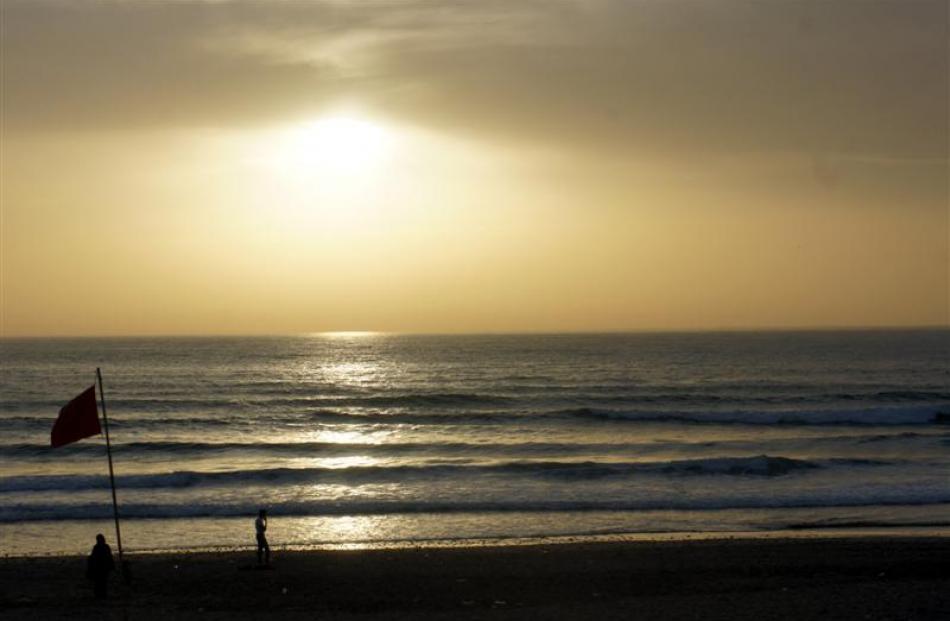 The sun sets over surf at Dar Najmat beach.