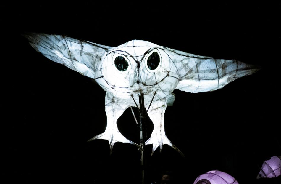 A huge owl swoops over the crowd at the Dunedin Midwinter Carnival procession.