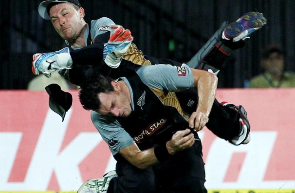 New Zealand wicketkeeper Brendon McCullum (top) collides with teammate Kyle Mills as he attempts...