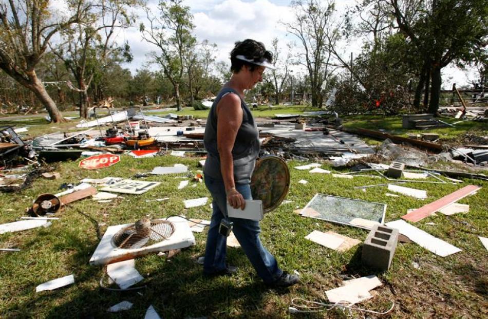 Linda McPike looks for her belongings in the remains of her home on Oak Island, Texas, on Monday....