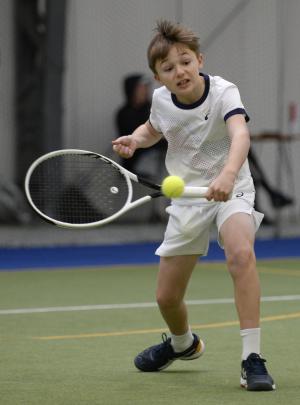 Noa Milburn (11), of Queenstown, glides across for a backhand return.