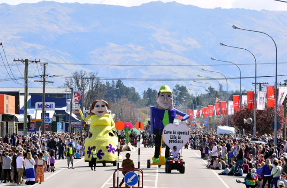 Spectators crowd Centennial Avenue as the floats make their way to Pioneer Park.