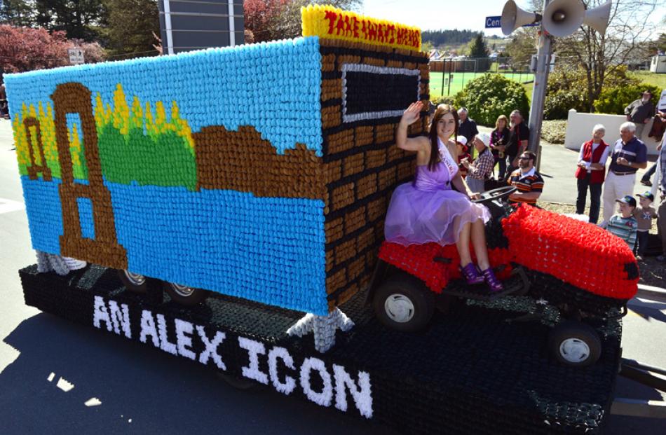 Bailey Sprosen waves from the Alexandra New World's float An Alex Icon, a depiction of the pie cart.