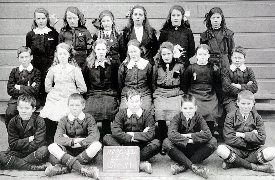 Boys and girls pose for a photo in 1913.
