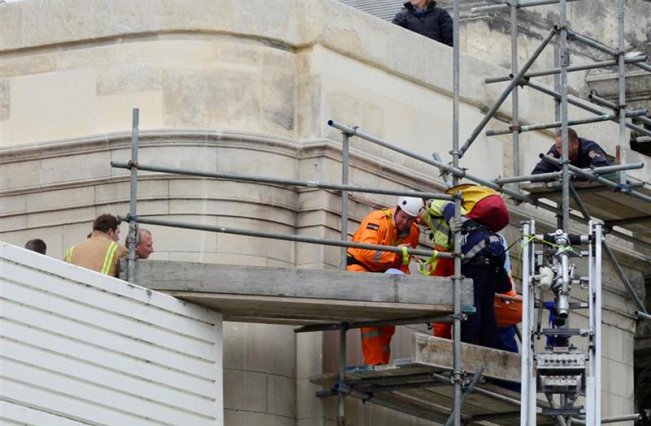 Emergency services staff ease the man in a Stokes basket across a temporary bridge between the...