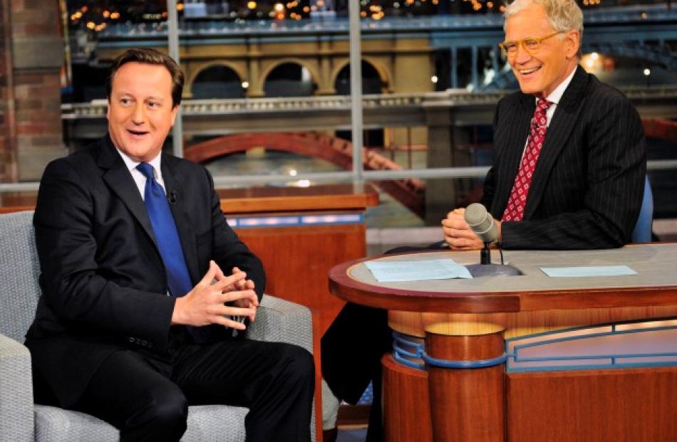 British Prime Minister David Cameron (L) talks with CBS Late Show host David Letterman during...