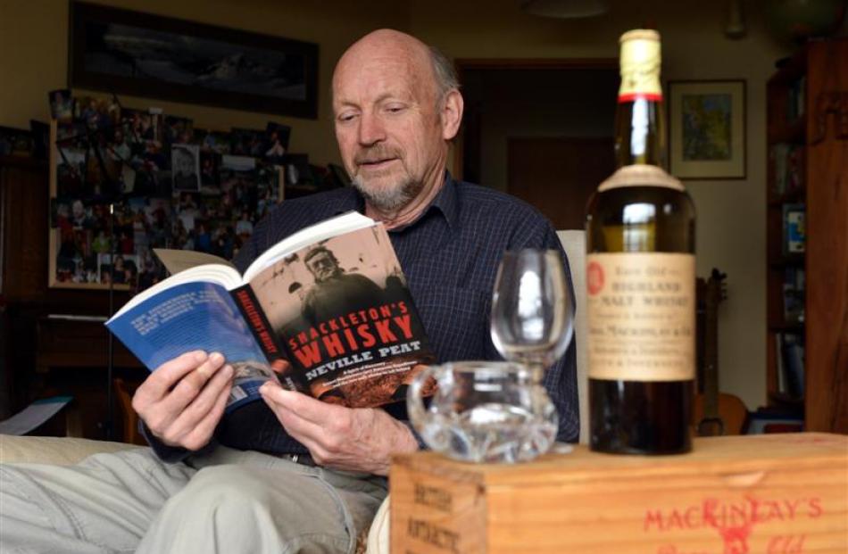 Neville Peat with a copy of his book and a bottle of Mackinlay's whisky. Photo by Stephen Jaquiery.