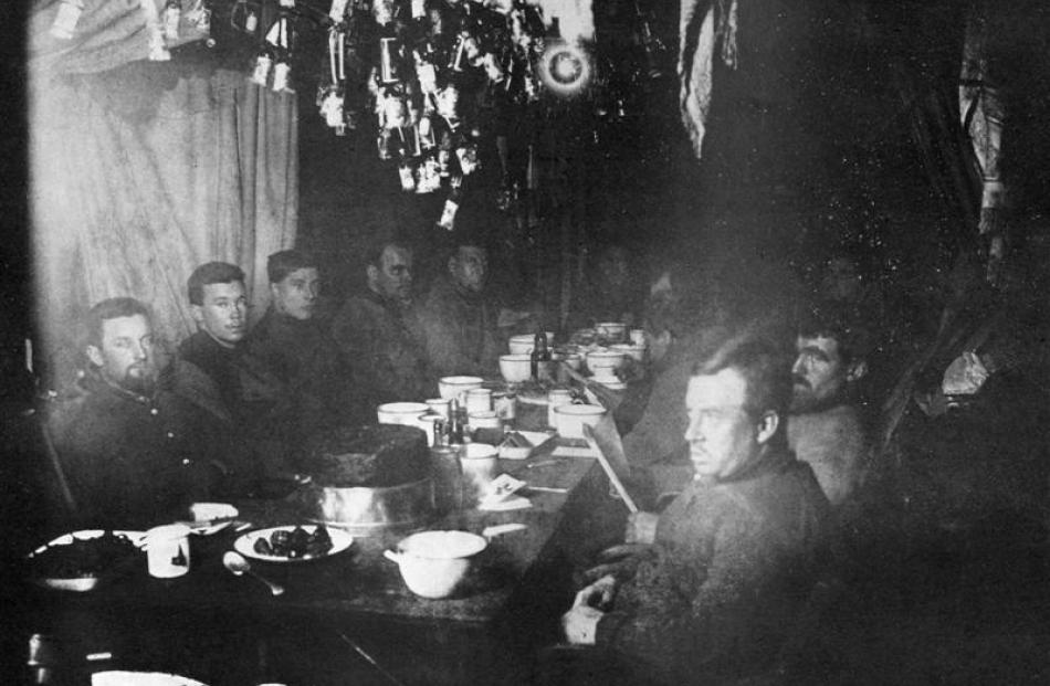The midwinter feast at the Nimrod Hut, Cape Royds, in June 1908. Ernest Shackleton is at the head...