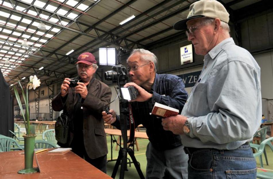 Kirby Fong (centre) photographs a premier bloom while Don Catons (left) from the United States...