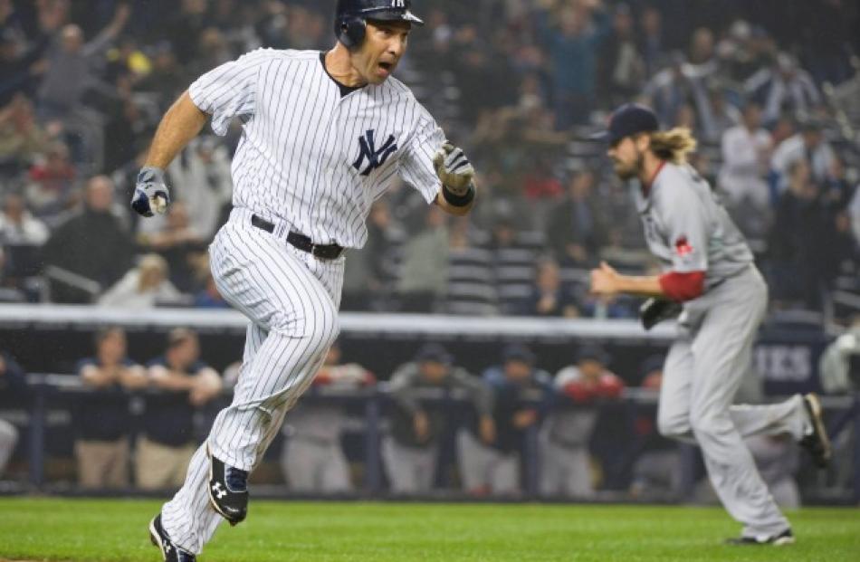 New York Yankees batter Raul Ibanez (L) celebrates after hitting a game-winning walk-off single...