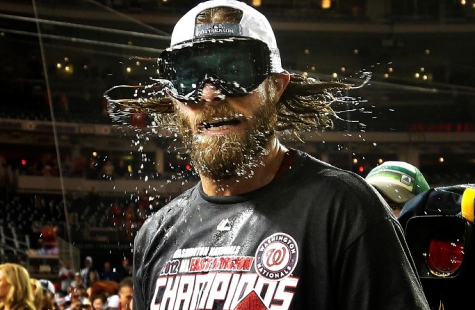 Washington Nationals' Jayson Werth shakes beer and champagne out of his hair and beard while...