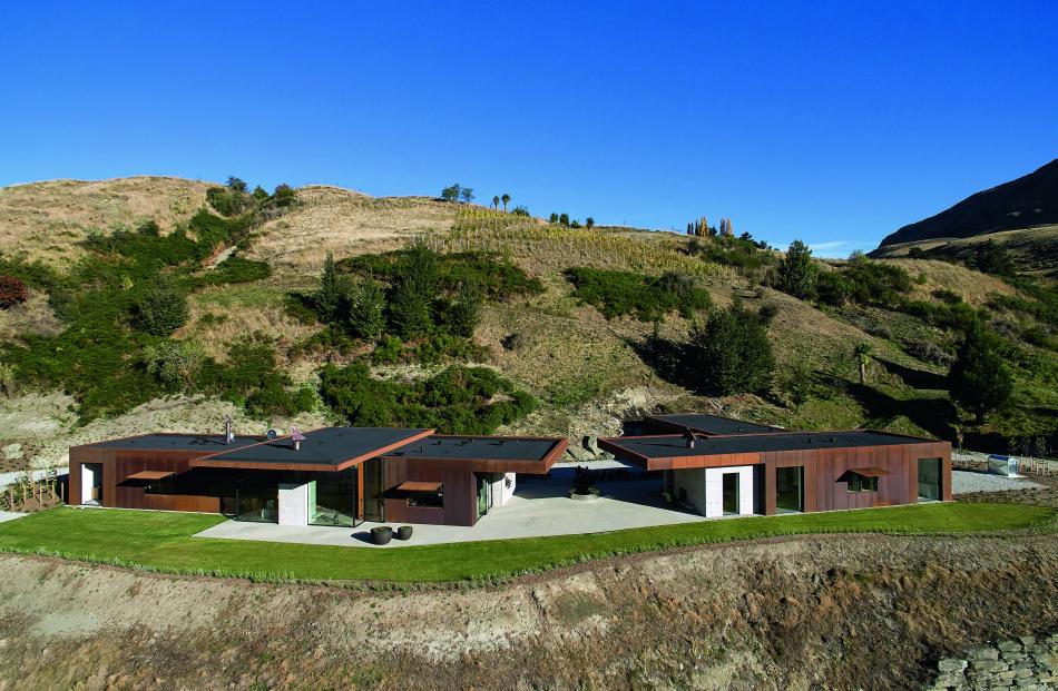 Nestled against a tussock-covered hill, this steel-clad Queenstown home sits perfectly within its...