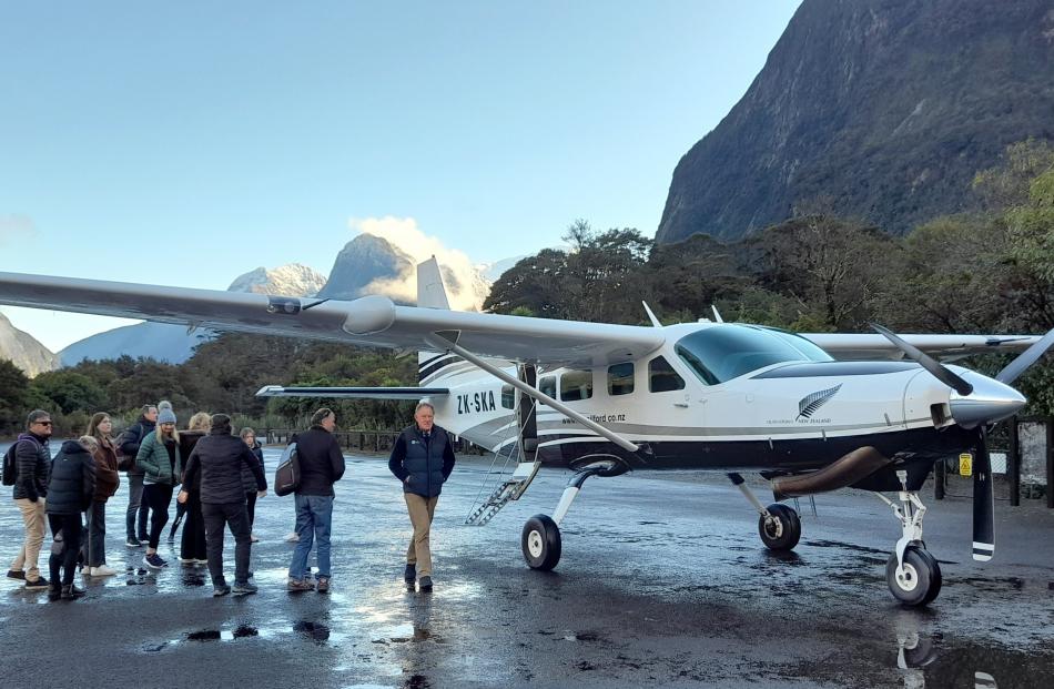 A group of tourists wait on the runway.
