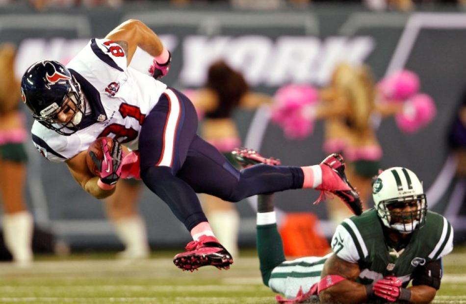 Houston Texans tight end Owen Daniels (L) breaks a tackle attempt by New York Jets safety...