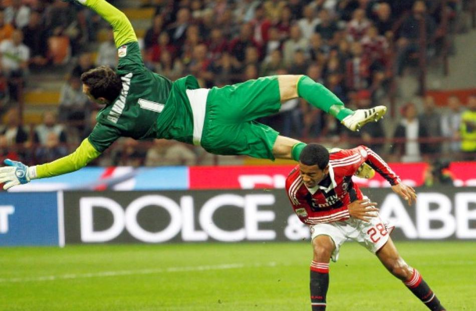 Inter Milan's goalkeeper Samir Handanovic (L) makes a save against AC Milan's Urby Emanuelson...