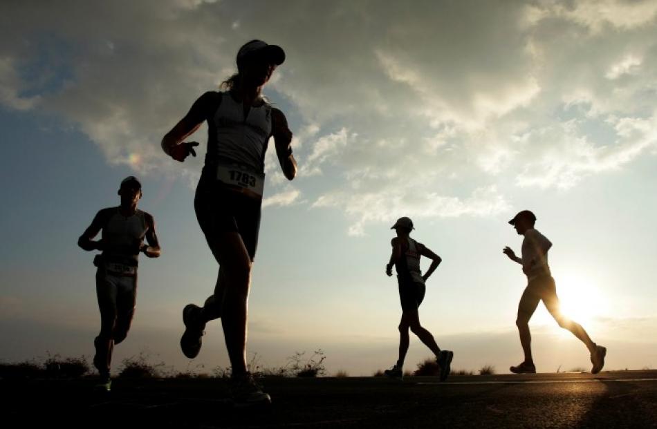 Amateur competitors run along Queen Kaahumanu Highway during the marathon section of the Ironman...