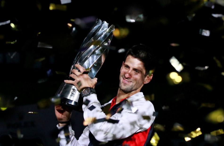 Novak Djokovic of Serbia celebrates with his trophy after beating Andy Murray of Britain to win...