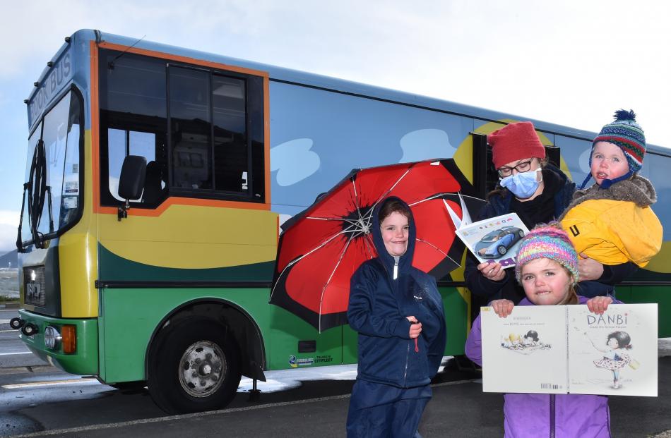 Enjoying a trip to the book bus on the first day of Alert Level 2 are Aliyah (7, left), Sarah,...