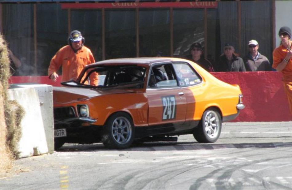 Safety marshals rush to check on Timaru driver Graeme Sargent after he crashed his Holden Torana...