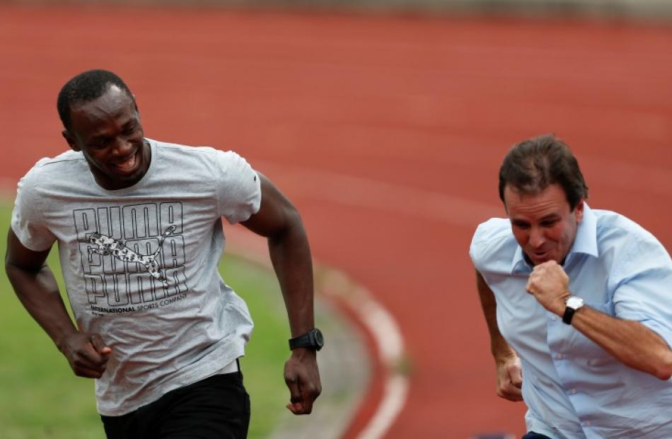 Jamaican Olympic gold medallist Usain Bolt (L) runs with Rio de Janeiro's Mayor Eduardo Paes at...