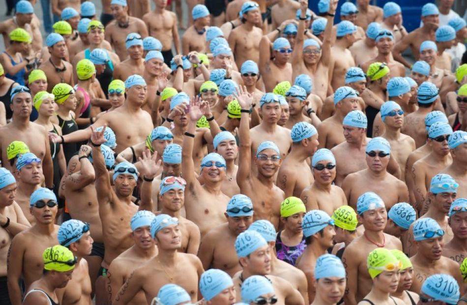 Participants wave as they prepare for the Cross Harbour Race in Hong Kong's Victoria Harbour....