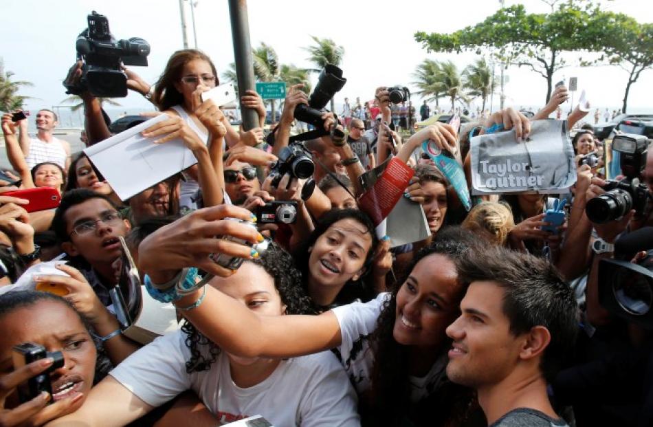 US actor Taylor Lautner poses for a picture with fans at a launch of the film 'A saga crepusculo:...