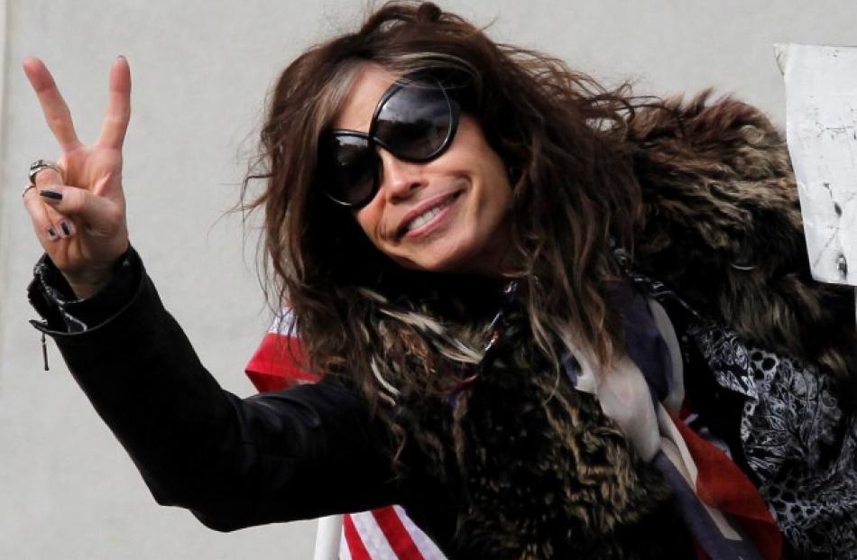 Aerosmith's Steven Tyler flashes a peace sign before the band's performance in Boston,...