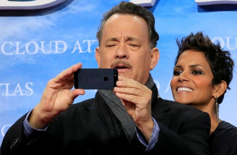 Cast members Tom Hanks and Halle Berry pose on the red carpet for the premiere of 'Cloud Atlas'...