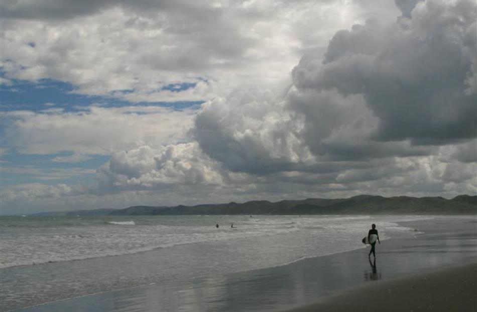 A surfer emerges from the sea at Ngarunui Beach.