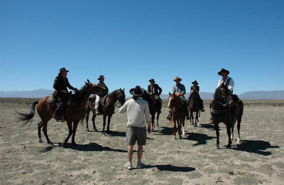 Director Mike Wallis talks to posse riding doubles on location  during the production of Good for...