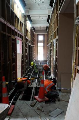 Contractors carry out strengthening work in a hallway.