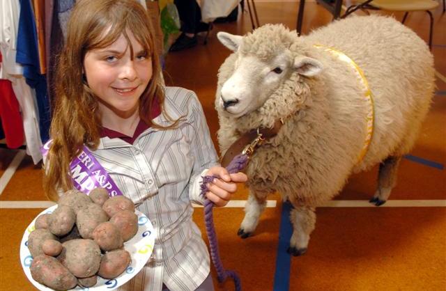 Elizabeth Graham with her prize winning potatoes and her pet sheep Fuzz which won 3rd in the pet...