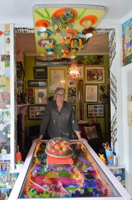 Artist Janet de Wagt beneath the upside-down dinner setting in her lounge. Photos by Gerard O'brien.