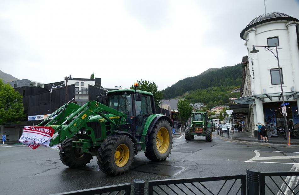 Tractors emblazoned with protest banners drive up Shotover St into the centre of Queenstown...