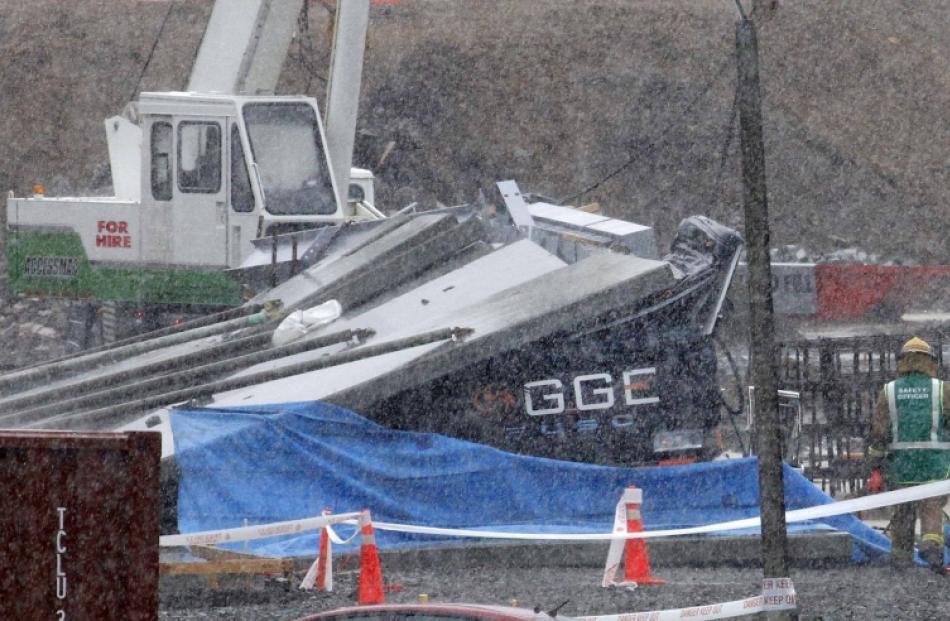 Rescue workers inspect the scene where at least two men are believed to be dead inside a truck ...