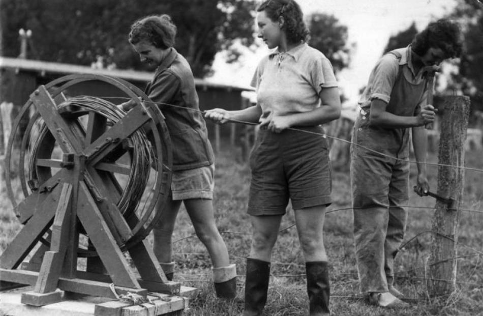 Land girls take down a wire fence. Photo supplied.