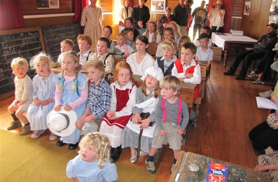 Children listen attentively (left) during a period class re-enactment in the Cardrona Hall.