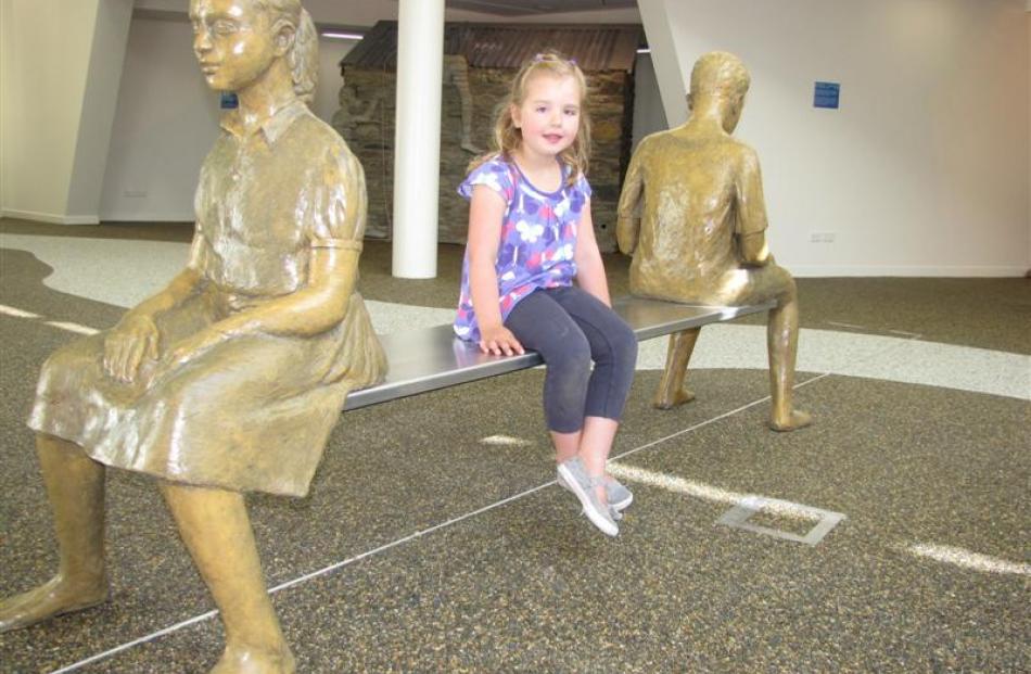 Jemma Spear tries out the ''Impossible Bench Seat'' sculpture, made by Derek Ball, of Ruby Bay.