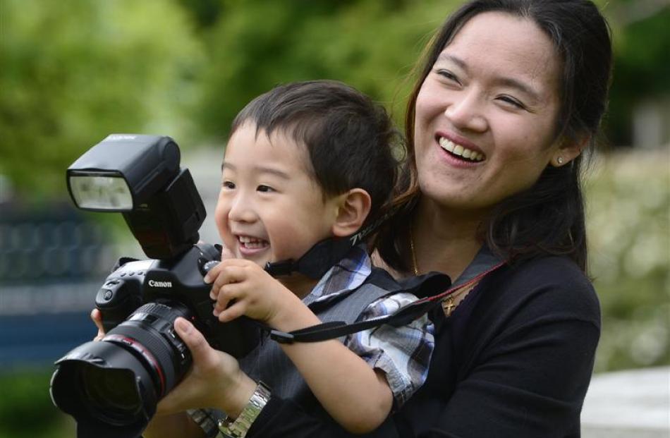 Tammy Leong checks pre-graduation photographs at the University of Otago yesterday, with a little...