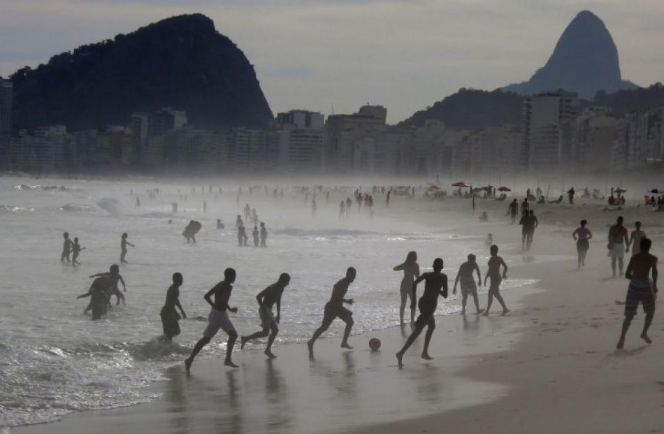 Boys play football at the edge of the surf at Copacabana Beach in Rio de Janeiro, Brazil. REUTERS...