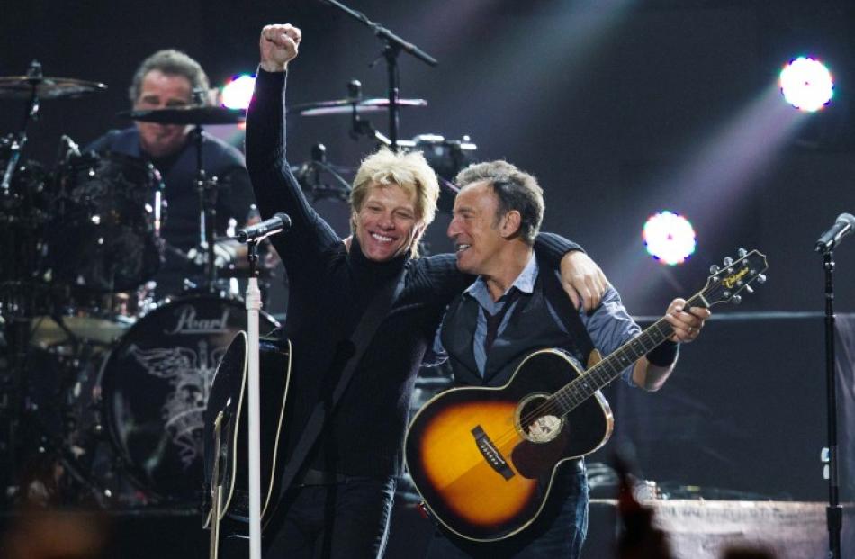 Singers Bon Jovi (L) and Bruce Springsteen perform during the '12-12-12' concert in New York....