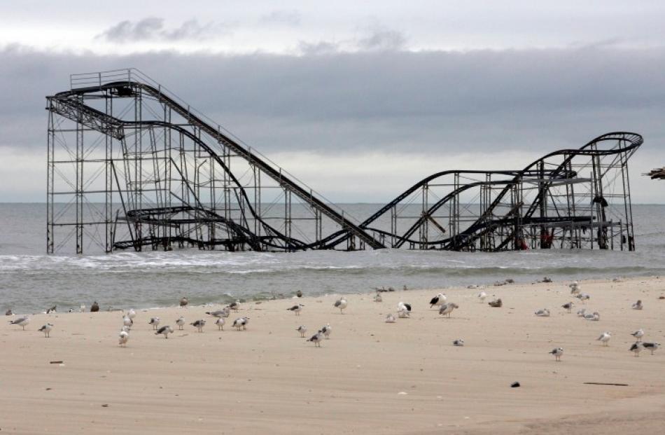 An amusement park roller coaster lies partially submerged in Seaside Heights, New Jersey after...