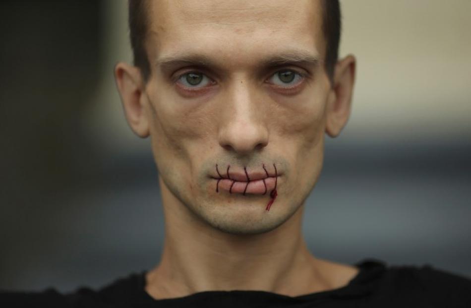Artist Pyotr Pavlensky, with his mouth sewn up, takes part in a protest in support of Russian...