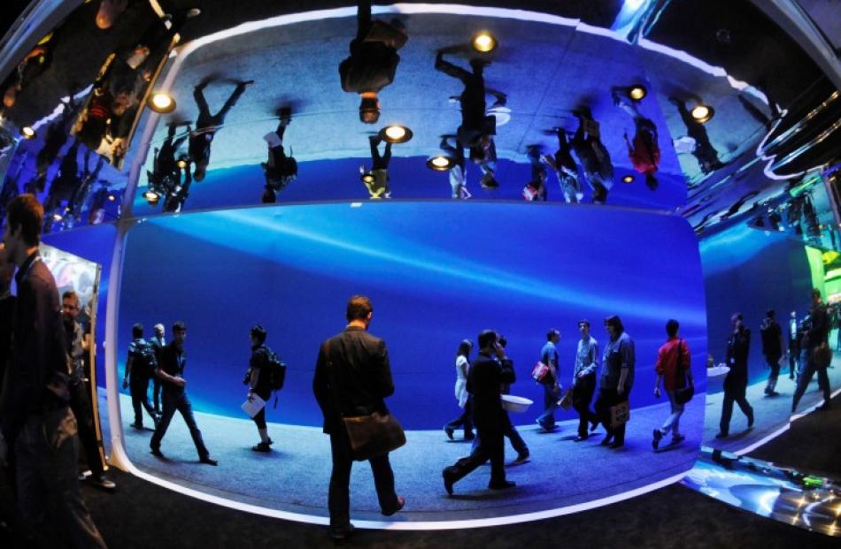 Attendees pass between display areas during the Electronic Entertainment Expo (E3), in Los...